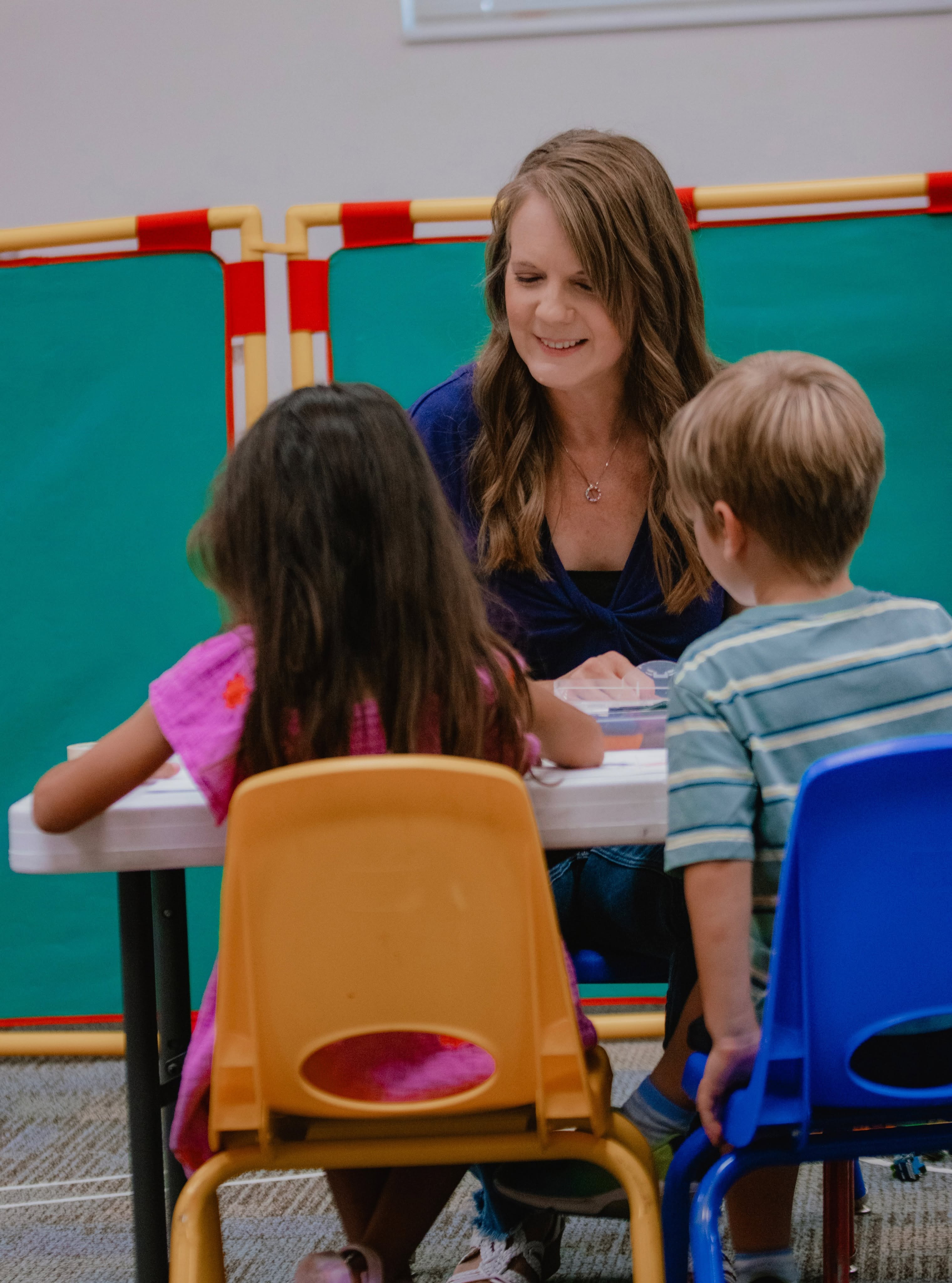 A Kid Life volunteer sharing a moment with children at a table